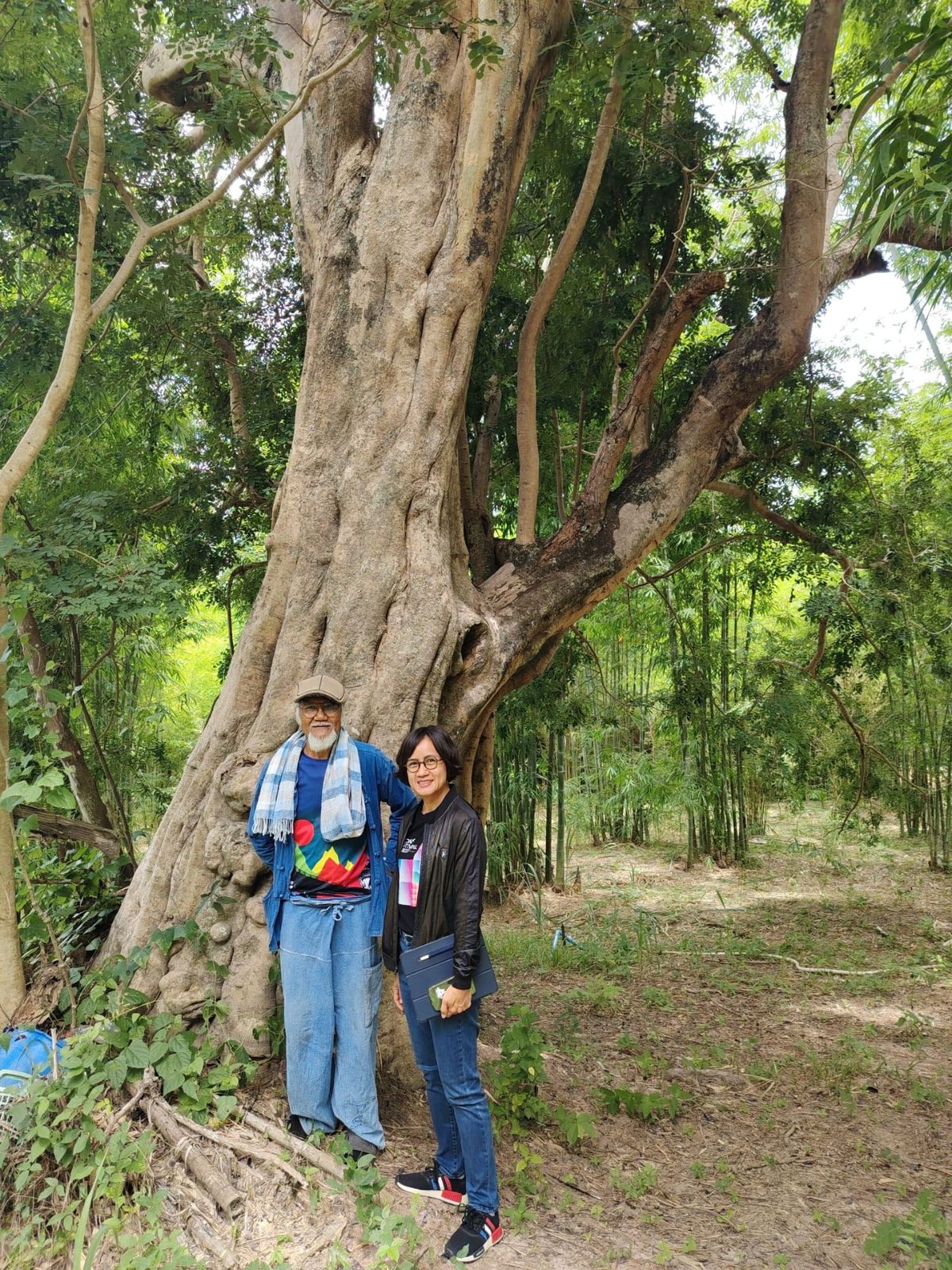 Loong Choke 和一位游客在泰国呵叻 Bamboo Forest School 的一棵大森林树下