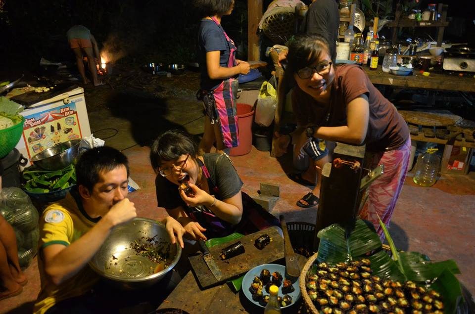 Community members sharing a communal home-grown meal around a table in the evening at Gaia Ashram.