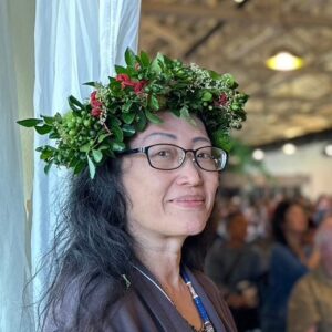 Hui-i Chiang, permaculture educator and co-founder of Earth Passengers, Taiwan, wearing a green flower head-wreath at a gathering.