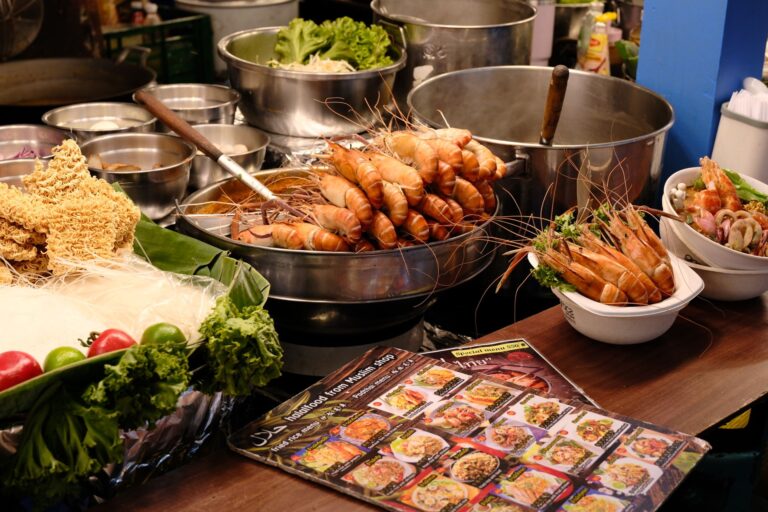 ร้านอาหารริมทางไทยที่จัดแสดงกุ้งแม่น้ำย่างและอาหารทะเลสด