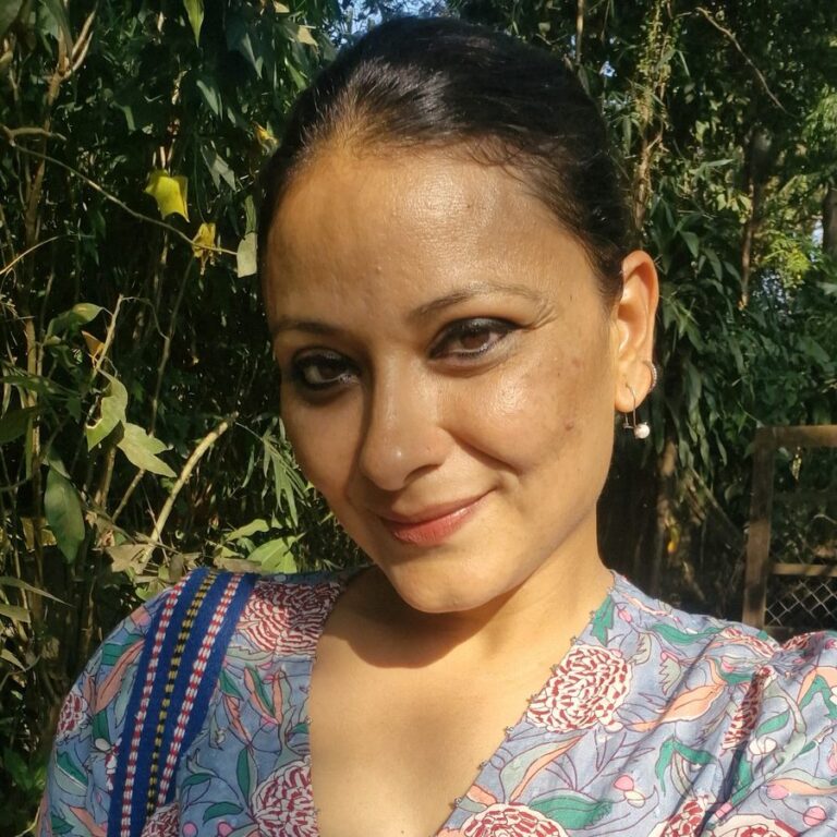Manasvini Tyagi, founder of Earthen Routes Community Farm in Navi Mumbai, in a floral blouse among trees.