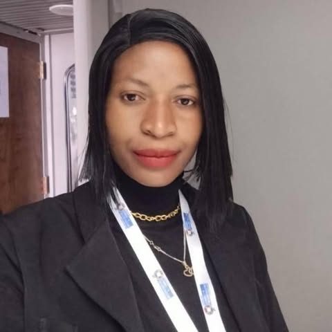 Odetta Kaonda, founder of Mother Earth Initiative, in a dark blazer and lanyard.