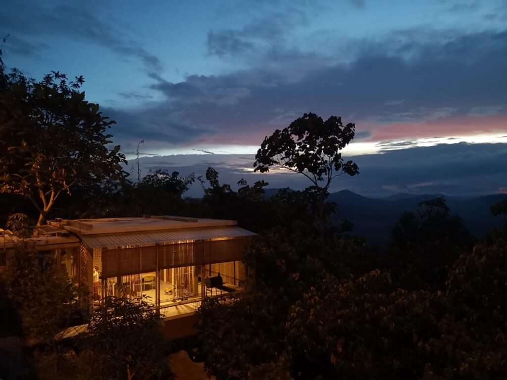 Bamboo Retreat at dusk, a lit building among trees above forested hills, Kuala Kubu Bharu Heights, Malaysia