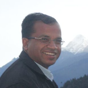 Govinda Sharma, founder of HASERA, smiling in front of Himalayan peaks.