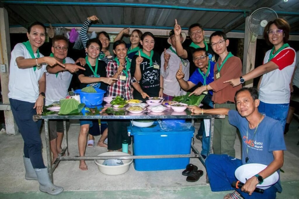 Participants around a table of local dishes on banana leaves at a previous course at the Mab Ueang Agri-Nature Centre